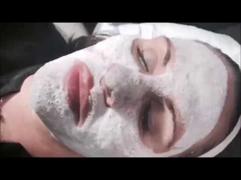 Woman receiving facial treatment with mask.