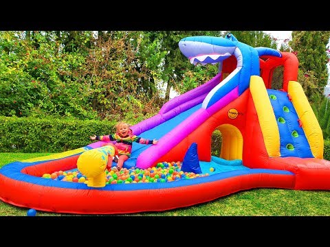 Alisa and Pink Pig ride on an inflatable slide