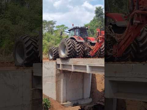 The tractor's wheels were sticking out as it crossed the bridge.