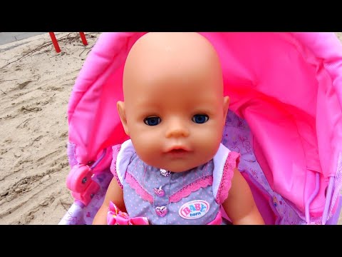 Baby born doll playing with sand molds on the playground