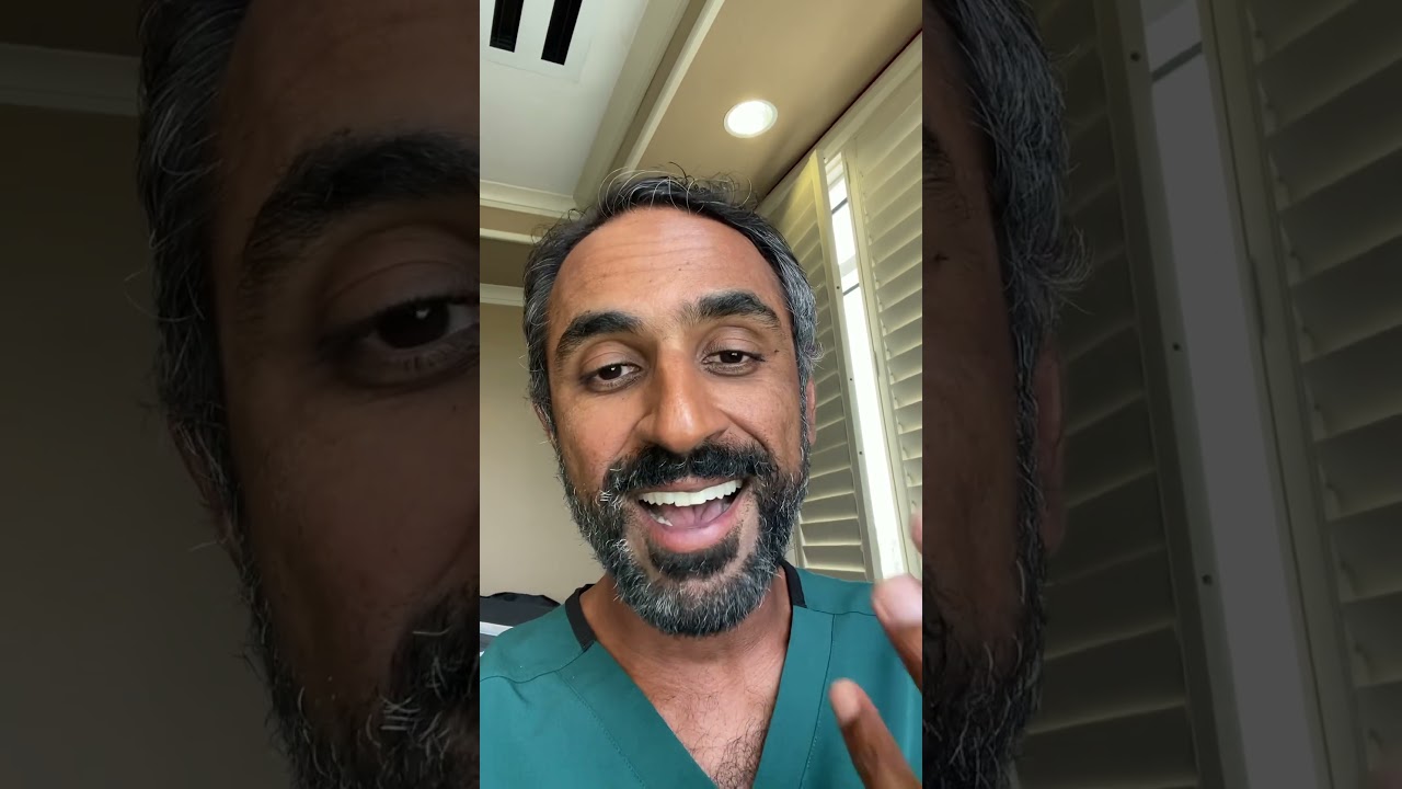 Smiling man in scrubs speaking to the camera.