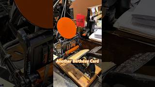 Letterpress printing another birthday card with orange ink using a tabletop printing press