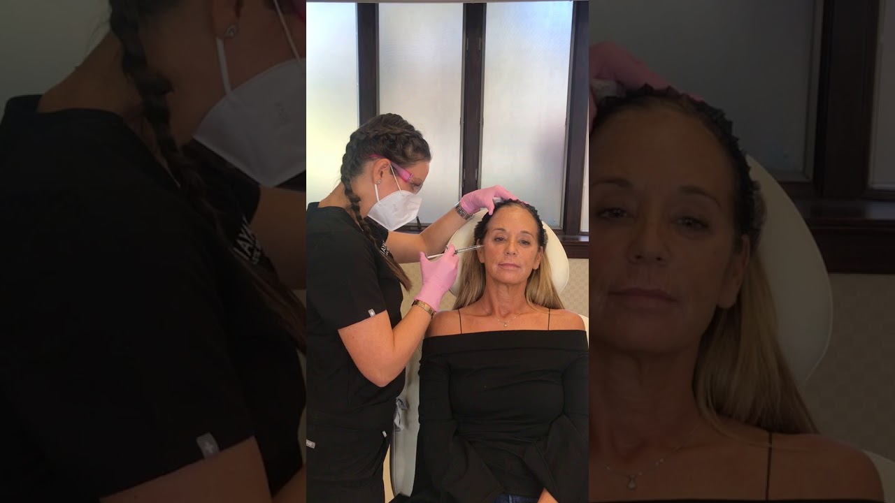Woman receiving cosmetic treatment in clinic setting.