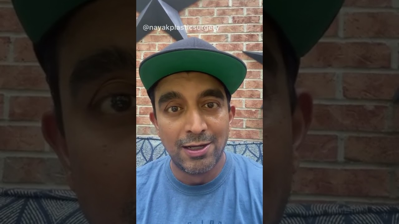 Person speaking in front of a brick wall.