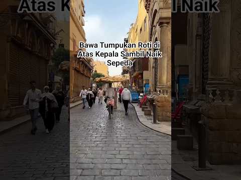 Bawa Tumpukan Roti di Atas Kepala Sambil Naik Sepeda