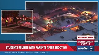 Parents line up at reunification site as buses unload students (must show ID)