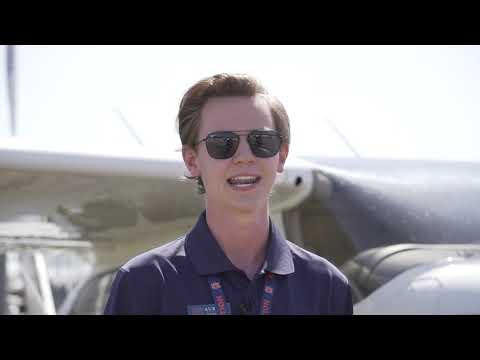 Blake of the Auburn Professional Flight Program in front of an airplane