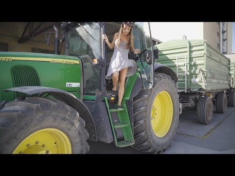 Farmer girl takes the harvest with the John Deere to the warehouse