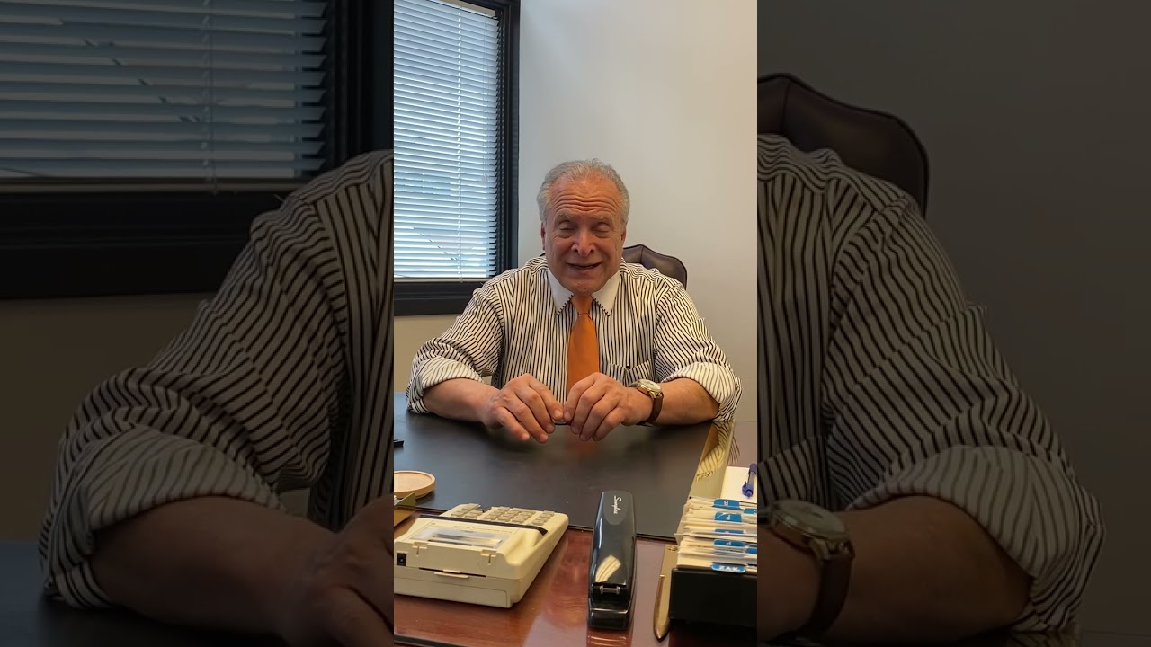 Smiling man sitting at a desk.