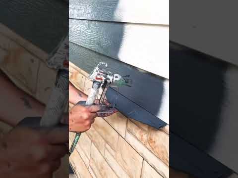 Application d'une peinture au pistolet sur bardage en bois