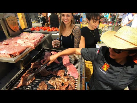 Street Food in Barcelona, Spain. Grilling Hanging Tenderloin Steaks. 'Meat&Fire' Grill Fest