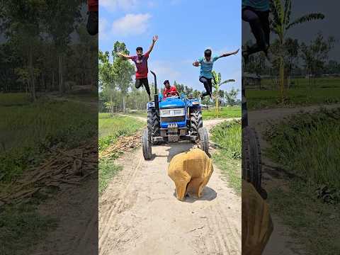 Two people are jumping in front of the tractor.,1