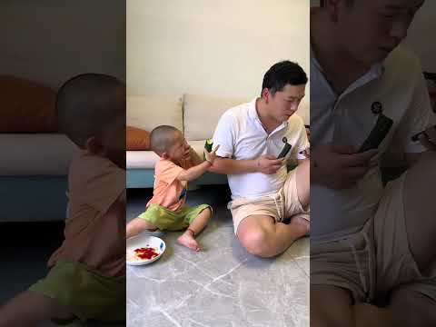 With a mobile phone in hand, everything tastes delicious. Naughty little guy, human cub, cute ba