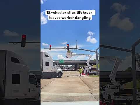18-wheeler clips lift truck, leaves worker dangling
