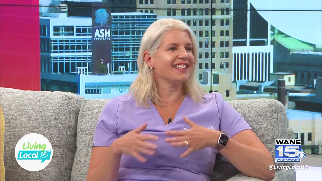 Woman in purple shirt discussing on a talk show.