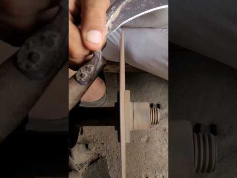 A mechanic sharpening a lawnmower