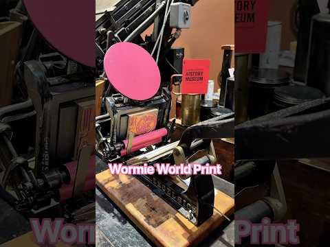 Letterpress printing pink Wormie World prints with a tabletop printing press