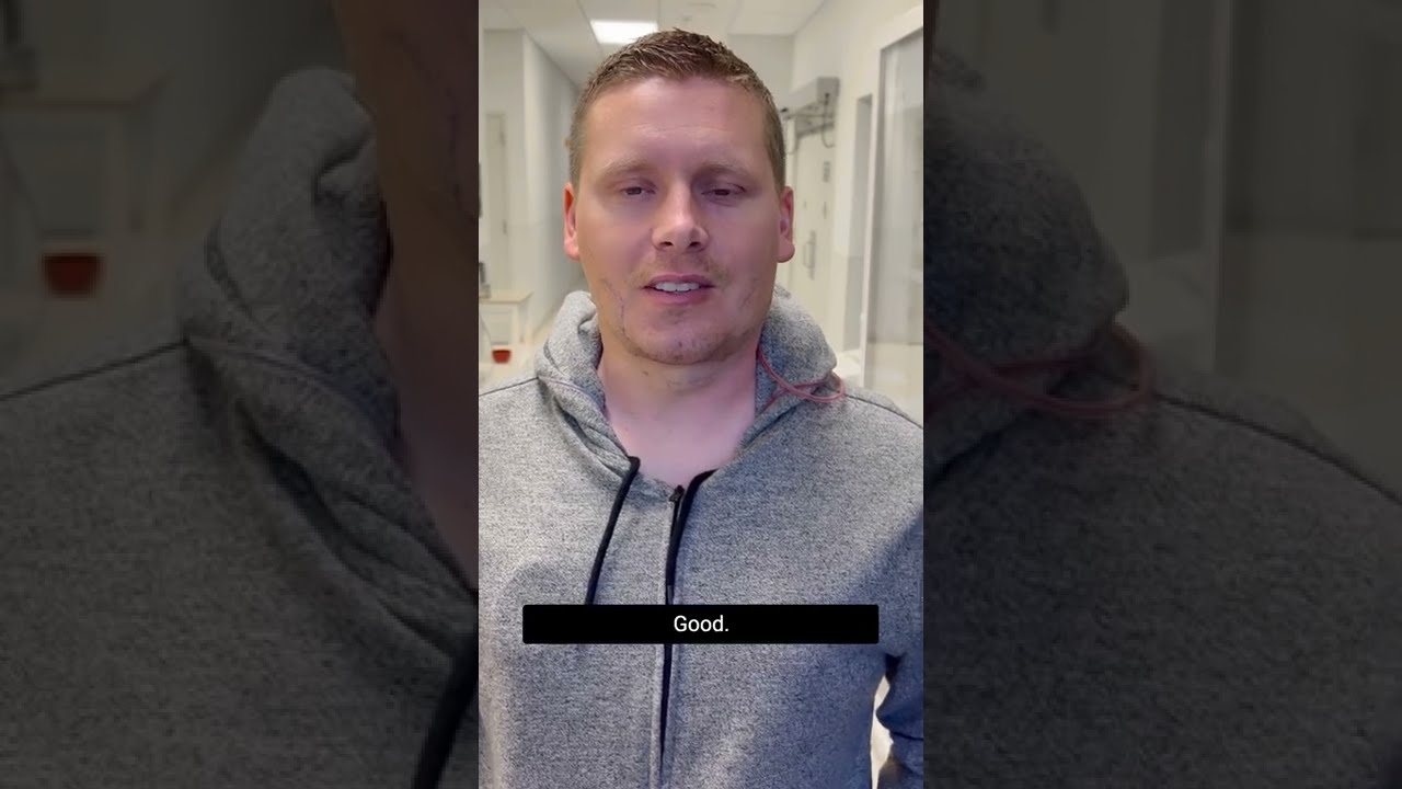 Man in a gray hoodie saying "Good."