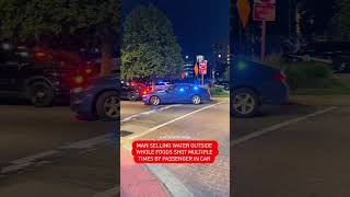 Person selling water outside Whole Foods shot