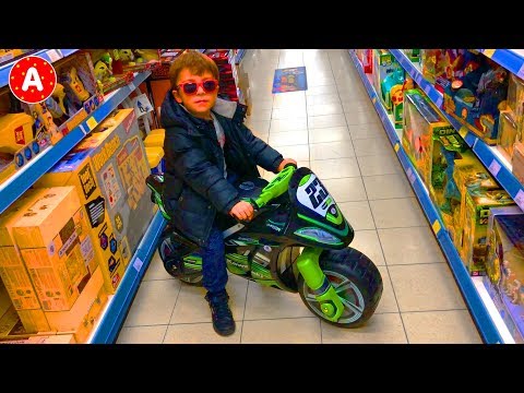 Little Boy Adam Playing with Toys in Toy Store for Kids