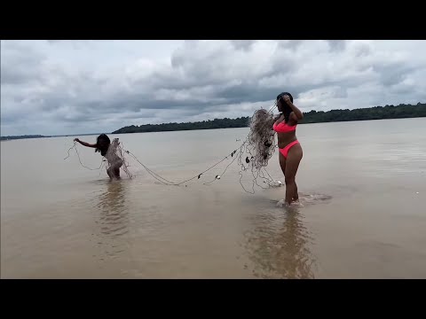 AS RIBEIRINHAS NA PRAIA DO CHAPÉU ASSANDO UM DELICIOSO PEIXE NA AREIA/LAGO AMANÃ/AMAZONAS.