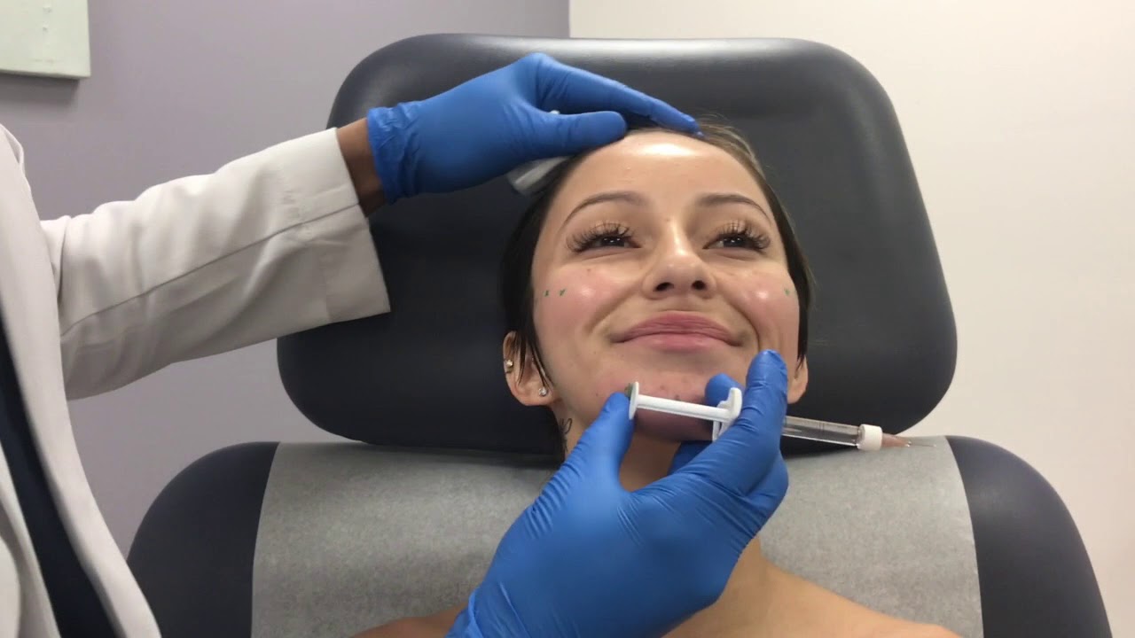Woman receiving skincare treatment in clinical setting.