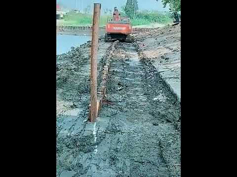 Use excavator Driving wooden pile underground