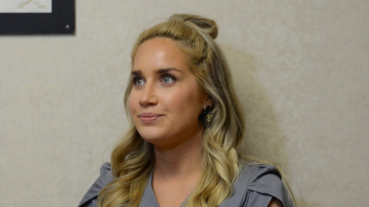 Woman with blonde hair looking thoughtfully off-camera.