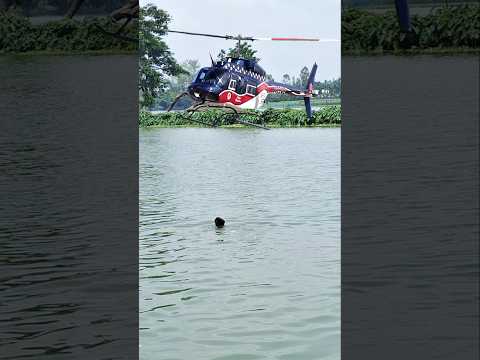 The Blue helicopter passing out over the village river