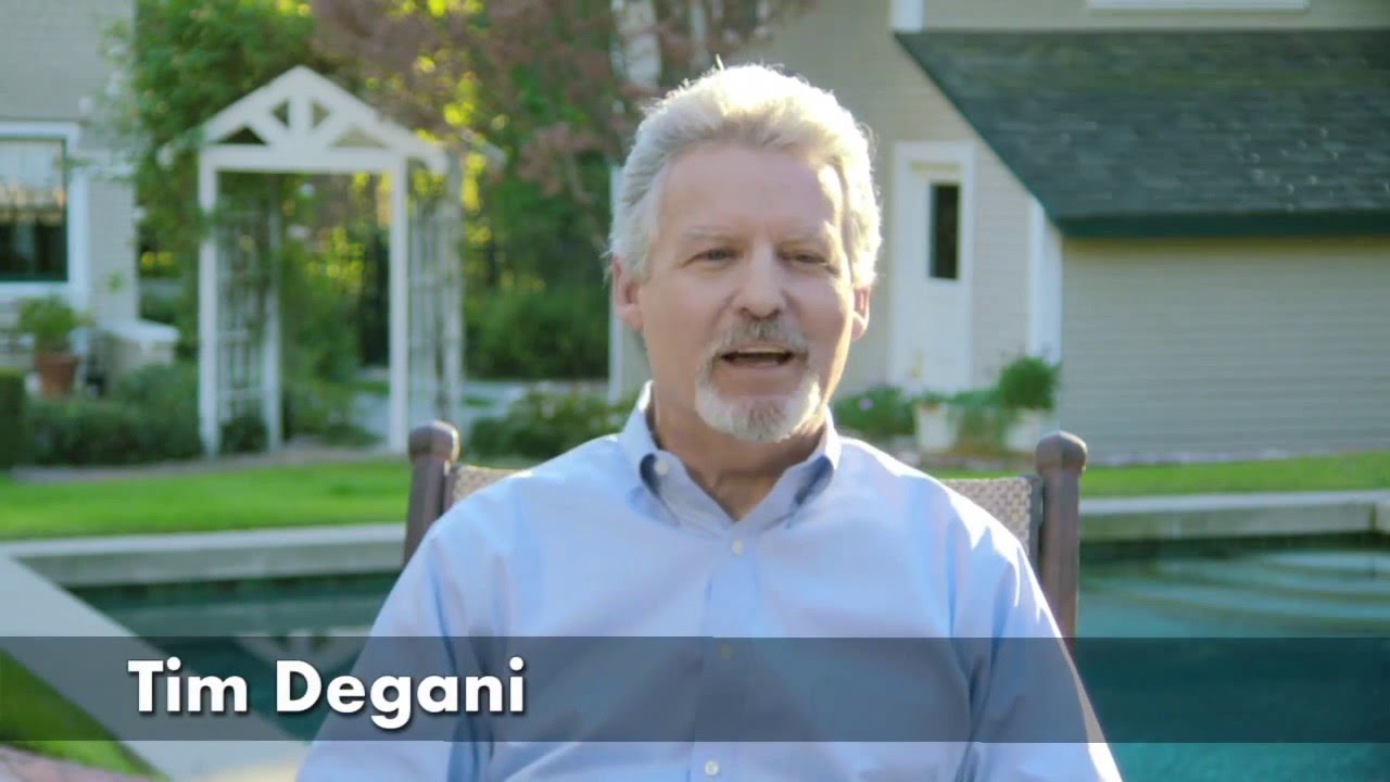 Man speaking outdoors in a garden setting.