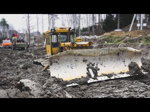 Бульдозер на болотных гусеницах залип в глине.