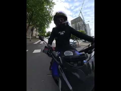 Woman on bicycle falls after crossing red light in front of motorcycle in Rotterdam, Netherlands