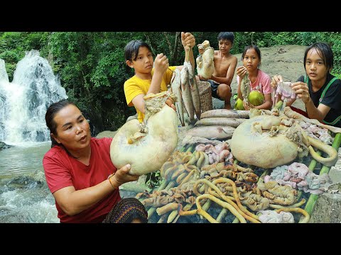 Woman cook pig intestines with fish in forest for eat