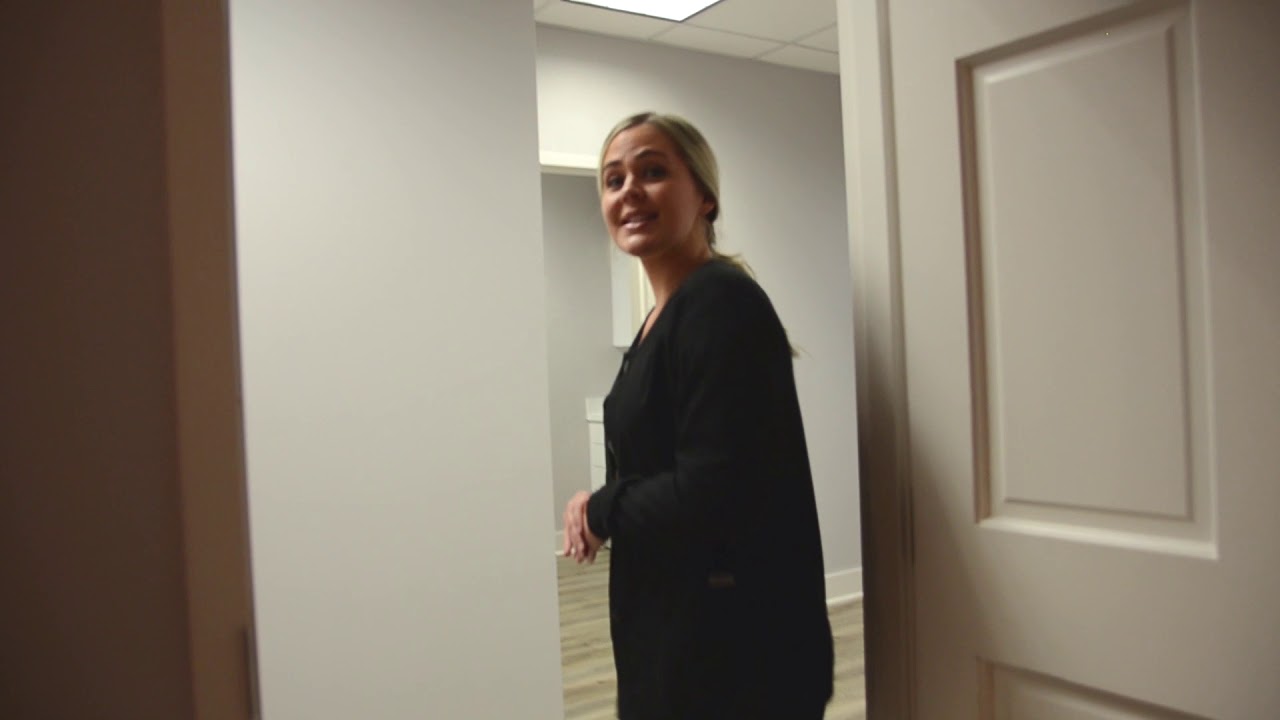 Person smiling while entering a room.