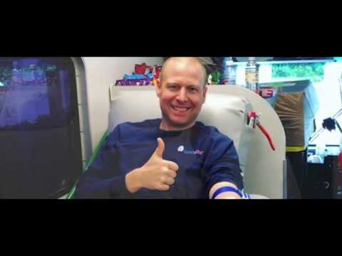 Man donating blood with a thumbs-up gesture.
