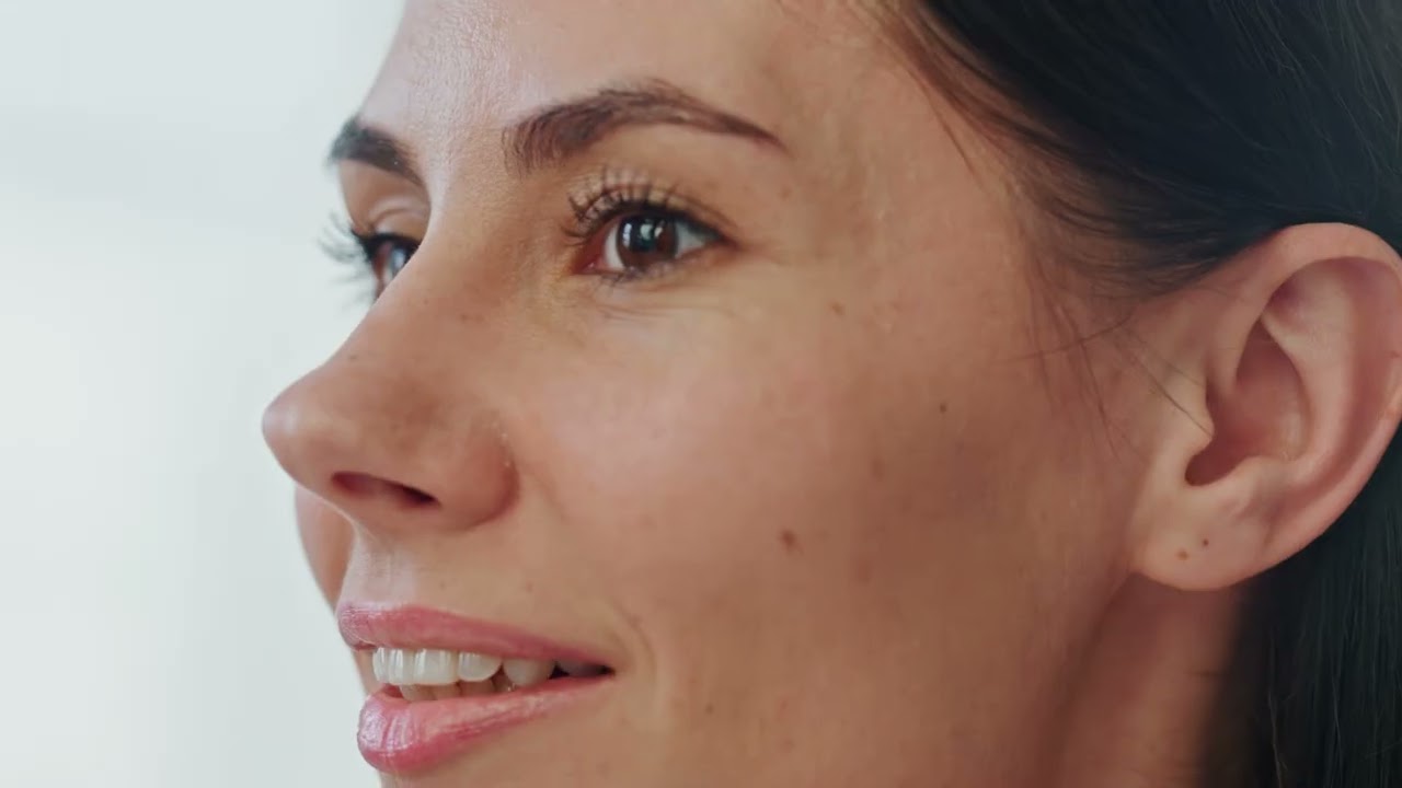 Close-up of a woman smiling and looking thoughtfully.