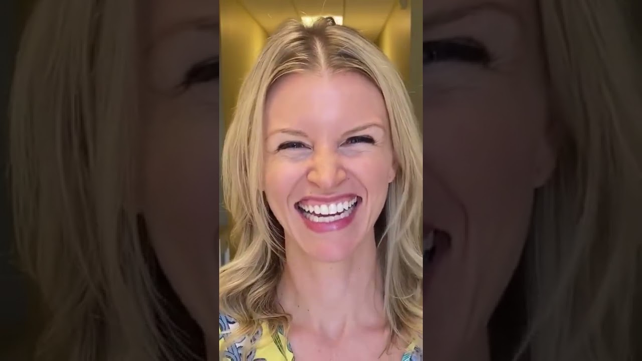 Smiling woman in brightly colored top.