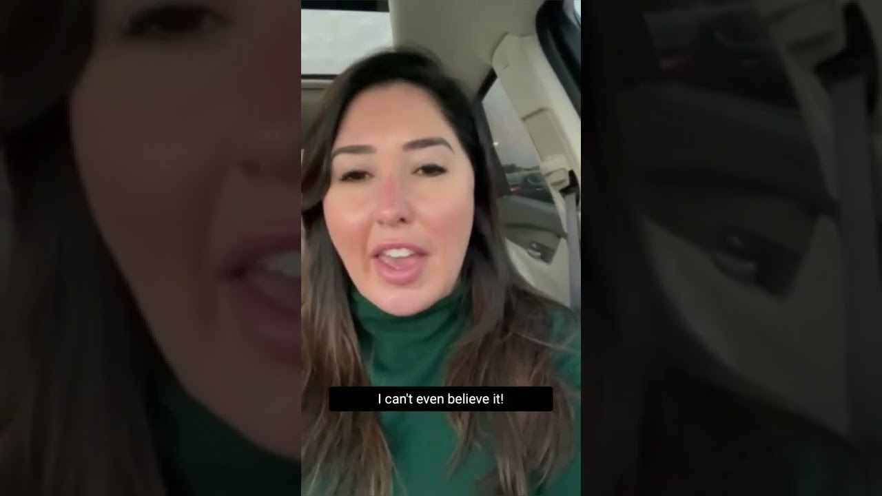 Person expressing surprise in a car.