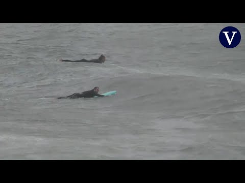 Surfistas aprovechan el temporal en la playa de la Barceloneta