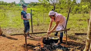 cooking delicious chicken with rice in the middle of a beautiful field in primitive style 4k
