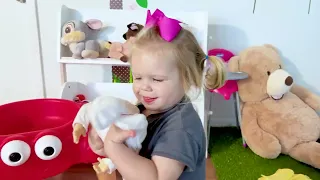 Cute toddler is playing with her doll in the playroom