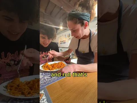 Cutting pasta with scissors in front of Italians