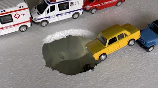 Diecast model cars fall into a hole with water