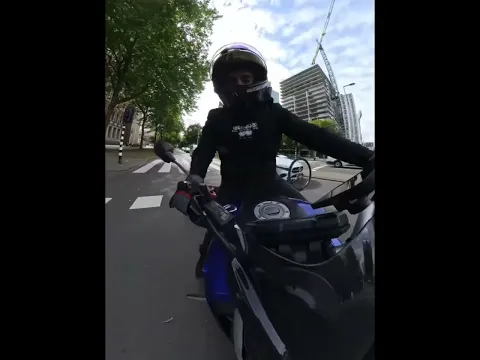 Woman on bicycle falls after crossing red light in front of motorcycle in Rotterdam, Netherlands